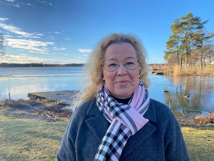 En kvinna framför en sjö.