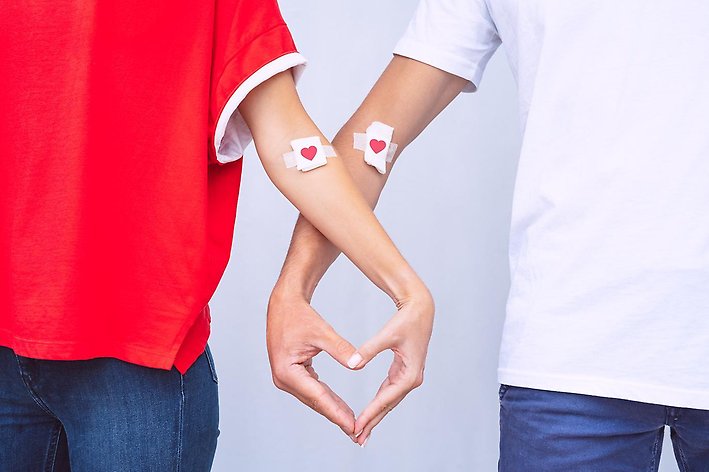 Två personer som skapar ett hjärta tillsammans med sina händer