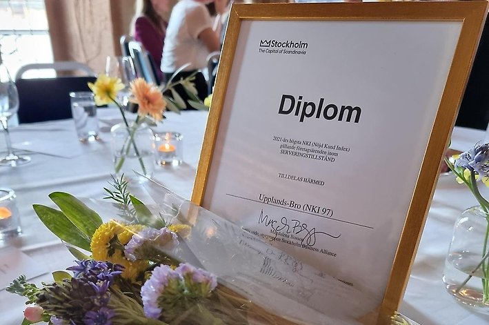 Bild på diplom som ligger på bord med blommor