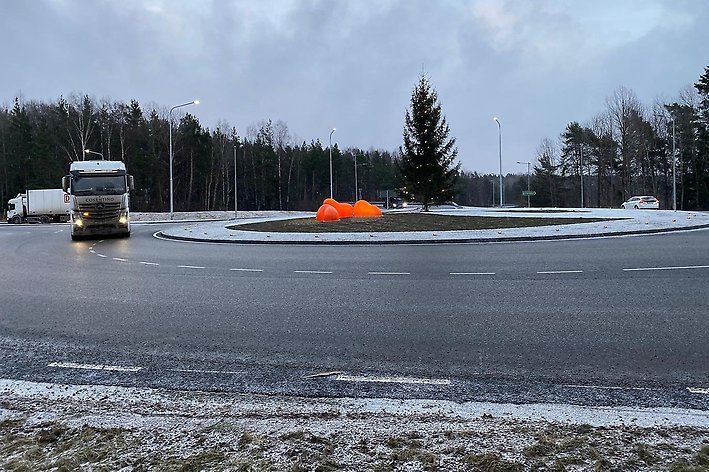 Foto på cirkulationsplats med julgran i mitten och en lastbil på vägen.