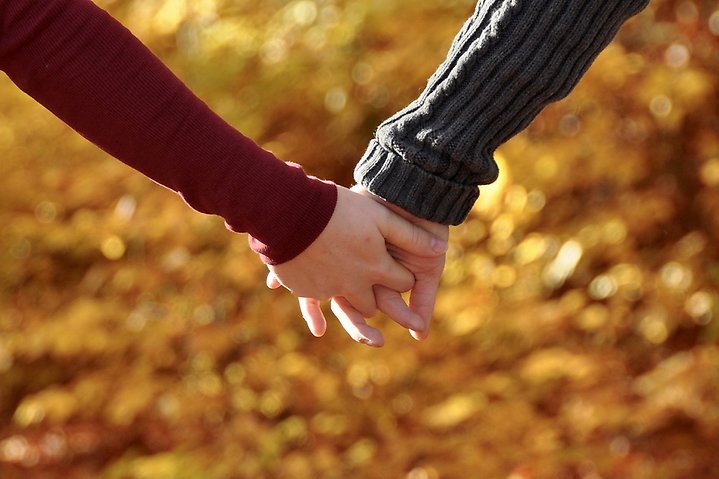 Foto på två personer som håller hand