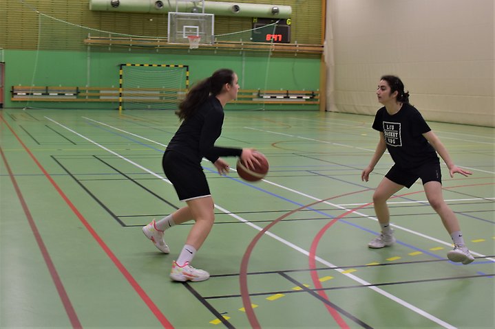 Foto på två tjejer som spelar basket